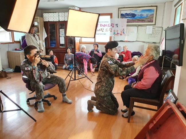 육군9사단 김훤주(왼쪽) 상사와 임효상 상병이 경기도 파주시 운정3동 어르신들의 장수사진을 찍어드리고 있다.  부대 제공