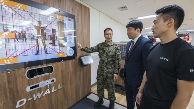30일 육군특수전사령부 전투력 회복센터 권오운(맨 왼쪽) 원사가 전투력 회복센터에 설치된 VR 기반 재활운동시스템 ‘D-WALL’에 관해 설명하고 있다.