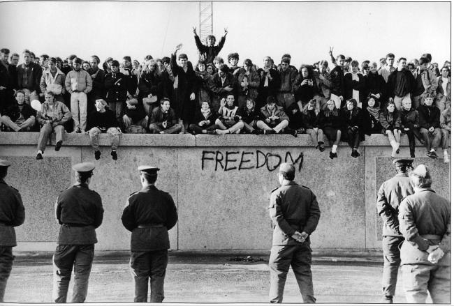 1989년 11월 동독의 학생들이 브란덴부르크 문에 있는 베를린 장벽에 앉아 있는 모습.  
 사진=radio.wosu.org
