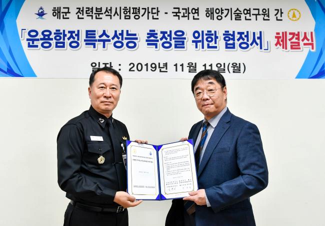 유선명(준장·왼쪽) 해군전력분석시험평가단장이 김찬기 국방과학연구소 해양기술연구원장과 ‘운용함정 특수성능 측정 용역사업을 위한 협정’을 체결한 뒤 함께 협정서를 들어 보이고 있다.   해군 제공