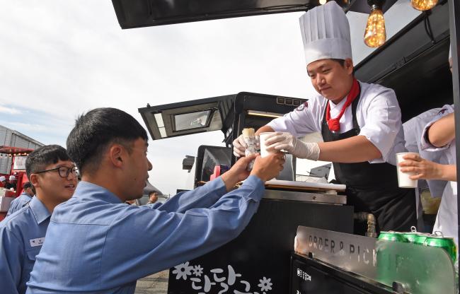 12일 진해군항에서 열린 네이비 쿡킹 선발대회에서 시식에 참가한 장병들이 조리 경연으로 만든 음식을 건네받고 있다.  해군 제공 