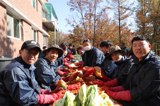 육군수도기계화보병사단 예하 비호여단 장병들이 김장 봉사를 하며 기념사진을 찍고 있다.  부대 제공