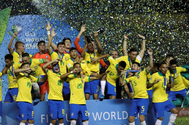 브라질 17세 이하(U-17) 축구대표팀 선수들이 18일(한국시간) 브라질리아의 베세랑 경기장에서 열린 U-17 월드컵 결승에서 멕시코를 2-1로 누르고 우승한 뒤 트로피를 들고 환호하고 있다. 브라질은 2003년 대회 이후 16년 만이자 통산 4번째(1997·1999·2003·2019) 우승을 차지하며 최다 우승팀인 나이지리아(5회)를 추격했다. 선제골을 내준 브라질은 후반 39분 페널티킥으로 1-1 동점을 이룬 뒤 후반 추가 시간 ‘극장골’로 짜릿한 승리를 거뒀다.     연합뉴스