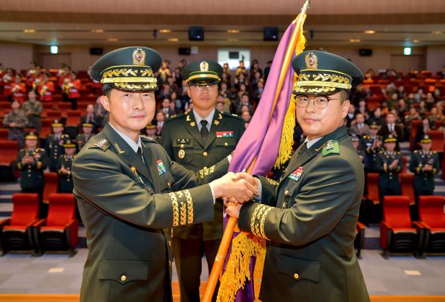 18일 열린 제45·46대 국방대학교 총장 이취임식에서 이임하는 이석구(왼쪽) 총장이 신임 김성일 총장에게 학교기를 건네고 있다.    국방대 제공