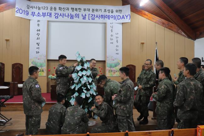 육군1군수지원사령부 7군수지원단이 개최한 ‘감사하데이(DAY)’ 행사에서 참석 장병들이 행사장 한편에 마련된 감사칭찬나무에 사연 열매를 적어 달고 있다.  부대 제공