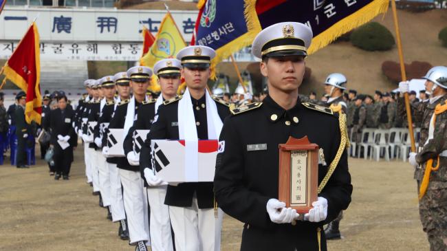 21일 육군1군단이 거행한 6·25 전사자 발굴유해 합동영결식에서 국방부 유해발굴감식단 장병들이 전사자 유해를 봉송하고 있다.  부대 제공