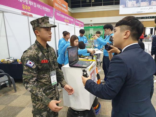 해병대6여단 심현보 병장이 대구 엑스코에서 열린 로봇경진대회 ‘2019 R-BIZ 챌린지’에서 대회 관계자와 인터뷰하고 있다.  한국로봇산업진흥원 제공 