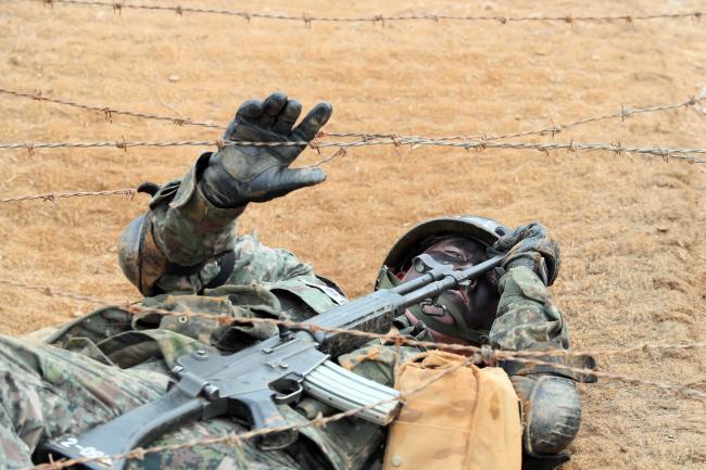 훈련병들이 장애물 지대에 구축된 철조망을 드러누워 통과 자세로 극복하고 있다. 사진=한재호 기자 