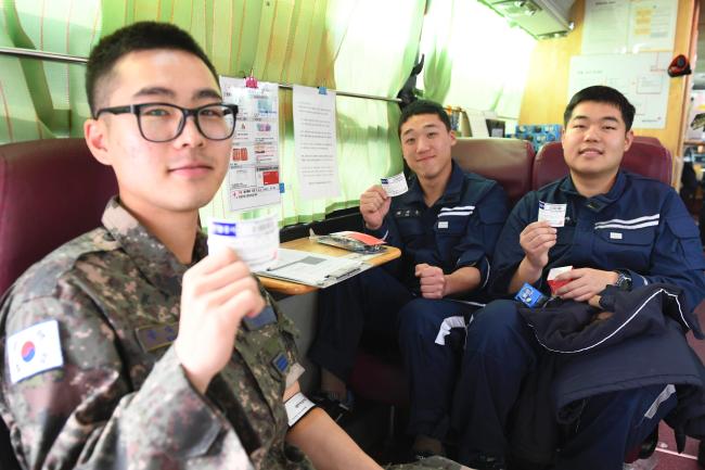 헌혈에 동참한 공군20전투비행단 장병들이 헌혈증을 들고 환하게 웃고 있다.   부대 제공