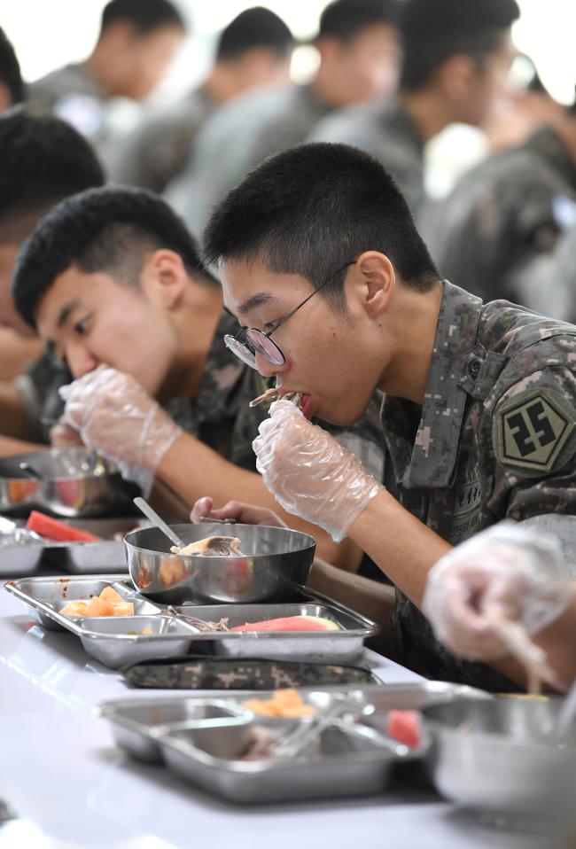 국방부는 올해 장병들이 훈련 뒤 가장 먹고 싶어하는 품목으로 꼽은 전복삼계탕의 급식을 확대할 계획이다. 사진은 지난해 7월 육군25사단 수색대대 장병들이 전복삼계탕을 먹고 있는 모습.   조용학 기자