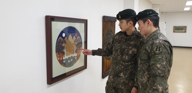 육군25사단 국사봉대대가 16일 개관한 영내 미술관 ‘국사봉 갤러리’에서 장병들이 전시된 미술 작품을 관람하고 있다.  부대 제공