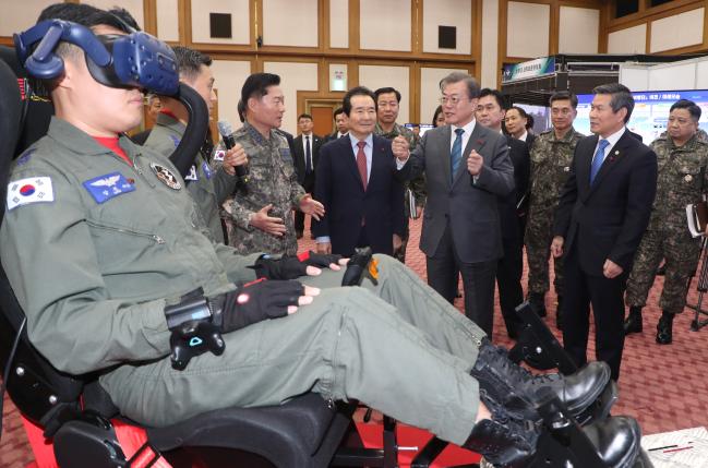 문재인(앞줄 오른쪽 둘째) 대통령이 21일 오후 충남 계룡대 본관 대회의실에서 국방부와 국가보훈처 업무보고를 받은 뒤 정세균(앞줄 오른쪽 셋째) 국무총리, 정경두(앞줄 맨 오른쪽) 국방부 장관과 함께 비행 교육훈련 등 4차 산업혁명 기술이 접목된 스마트 국방 혁신 시연을 관람하며 원인철(앞줄 오른쪽 넷째) 공군참모총장과 대화하고 있다.  연합뉴스