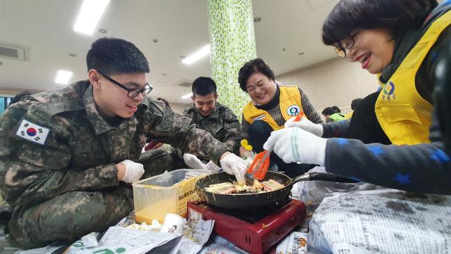 22일 충북 영동군 여성회관에서 육군8탄약창 장병들이 자원봉사자들과 함께 지역 소외계층에게 나눠 줄 음식을 만들고 있다.  부대 제공