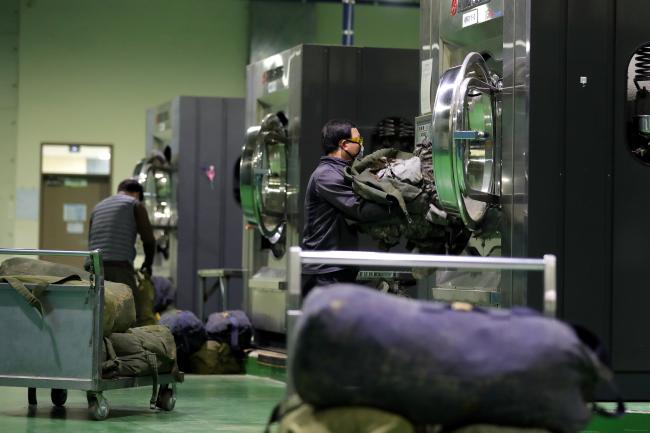 충남 논산 육군훈련소 크린센터에서 근무자들이 훈련에 이용한 훈련복들을 세탁기에 넣고 있다.  사진=조종원 기자