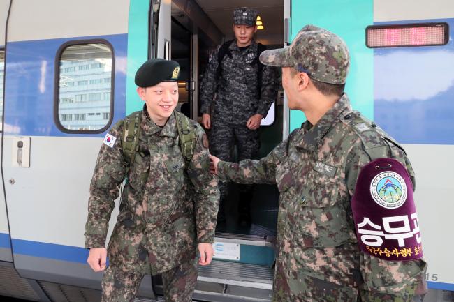 설 연휴 동안 국군수송사령부가 증편 운영한 군 전세객차를 이용해 귀경한 장병들이 26일 오후 서울역 승강장에 도착한 열차에서 내리며 여객지원을 위해 동승한 승무관과 인사를 나누고 있다.  한재호 기자