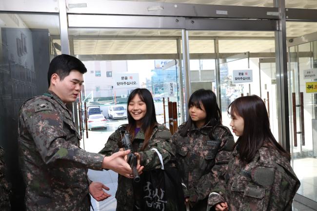 국군수송사령부 호송대대가 진행한 청소년 진로체험 활동에서 부대를 방문한 청소년들이 호송작전에 사용되는 화기를 직접 들어보고 있다. 사진 제공=이의현 대위