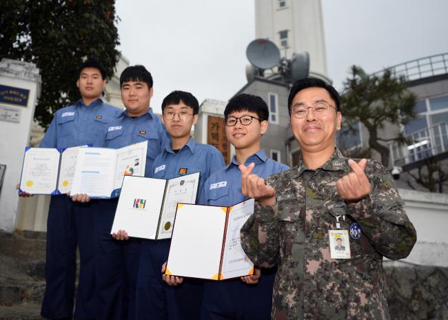 해군진해기지사령부 항만방어전대 소속 신동일(맨 오른쪽) 상사가 봉사활동을 위해 취득한 자격증을 보이며 부대원들과 함께 포즈를 취하고 있다.  사진 제공=신승우 하사