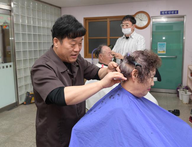 공군15특수임무비행단 소속 한방 군의관(사진 위)과 이발 담당 군무원들이 29일 부대 인근 복지관에서 지역 어르신들을 대상으로 의료 및 미용 대민지원을 하고 있다.  부대 제공