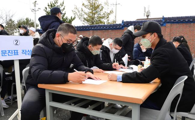 해군병 664기, 의경 404기 장정들이 17일 해군교육사령부 입영에 앞서 코로나19 관련 특이사항 유무 확인을 위한 문진표를 작성하고 있다.   사진 제공=박미현 중사