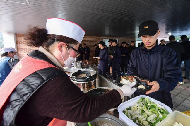 지난 15일 해군1함대 장병들이 부대 안에 설치된 묵호야시장 푸드코트에서 지역상인으로부터 음식을 받고 있다. 
  사진 제공=박보훈 중사 