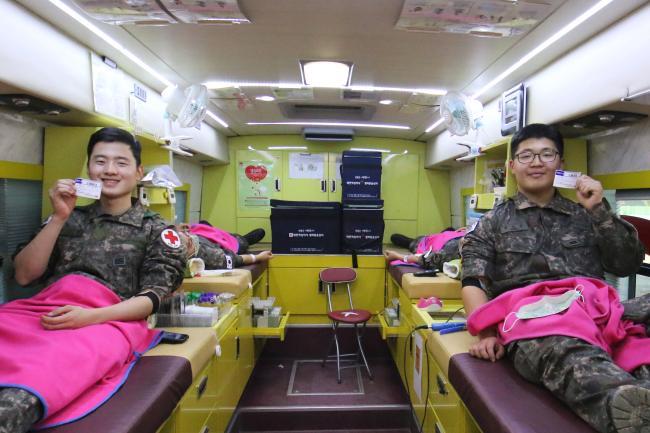 사랑의 헌혈에 동참한 육군102기갑여단 장병들이 헌혈 후 받은 헌혈증을 들어 보이고 있다. 

 부대 제공