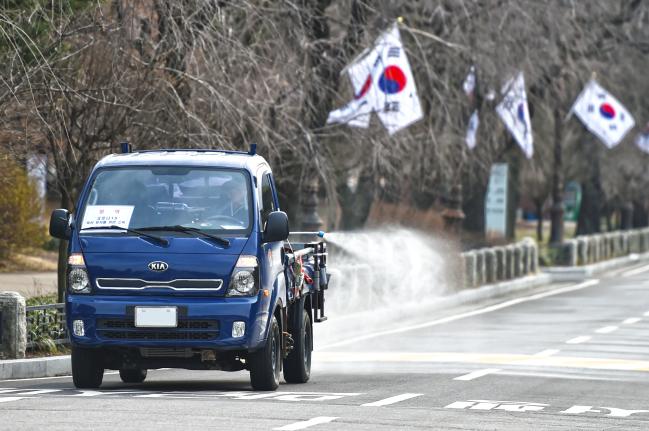 국립서울현충원이 24일부터 원내 주요 시설·도로에 대한 방역작업을 하고 있는 가운데 26일 현충문 입구 주변에서 관리 요원이 분무소독을 하고 있다.  서울현충원 제공