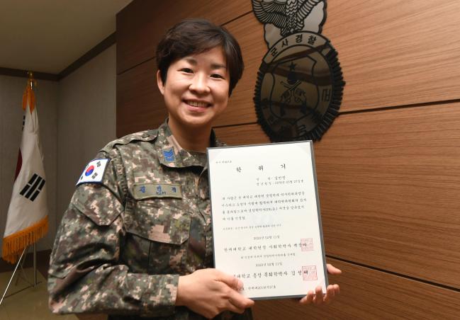 병영문화 개선을 위한 연구 주제로 최근 경찰학 박사 학위를 받은 공군군사경찰단 김민정 상사가 자신의 학위증을 들어 보이고 있다.  공군 제공