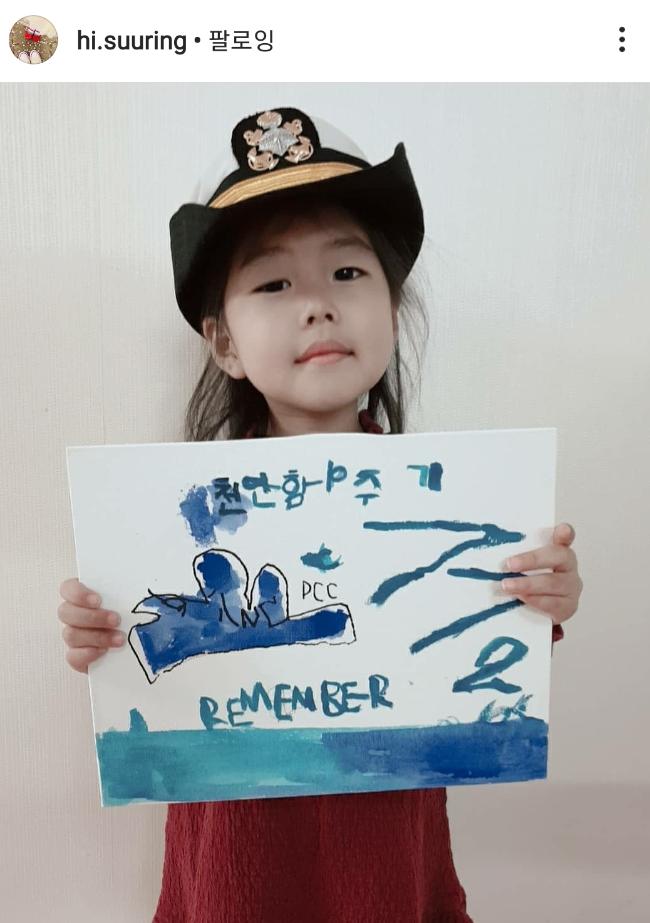 정웅선 해군대위의 딸 정희진 어린이가 천안함을 직접 그린 그림을 들어 보이며 ‘천안함 챌린지’에 참여하고 있다. 