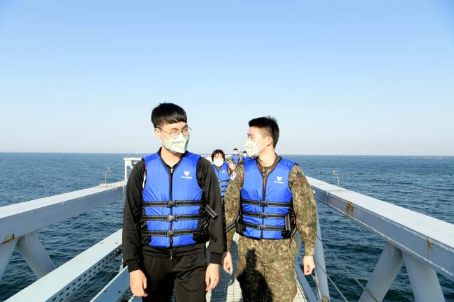 공군18전투비행단이 부대원들의 스트레스 경감을 위해 기지 해상 접근등을 산책로로 활용 중인 장병들이 25일 산책을 즐기고 있다.  사진 제공=김동범 중사