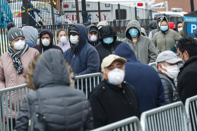 25일(현지시간) 미국 뉴욕 퀸스의 엘름허스트 병원 입구에서 시민들이 마스크를 쓴 채 코로나19 검사를 받기 위해 줄을 서서 차례를 기다리고 있다.     연합뉴스