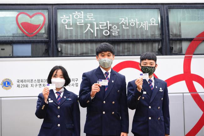 공군항공과학고등학교 학생들이 지난 26일 교내에 마련된 헌혈버스에서 헌혈을 마친 뒤 헌혈증을 들어 보이고 있다.  부대 제공