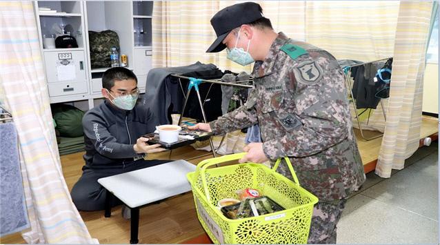 육군32사단에 마련된 임시훈련소에서 교관이 훈련병에게 도시락을 전달하고 있다. 사단은 매끼 취사병들이 직접 조리한 음식을 임시훈련소 대구·경북지역 훈련병들에게 일일이 포장해 전달했다.   

 부대 제공