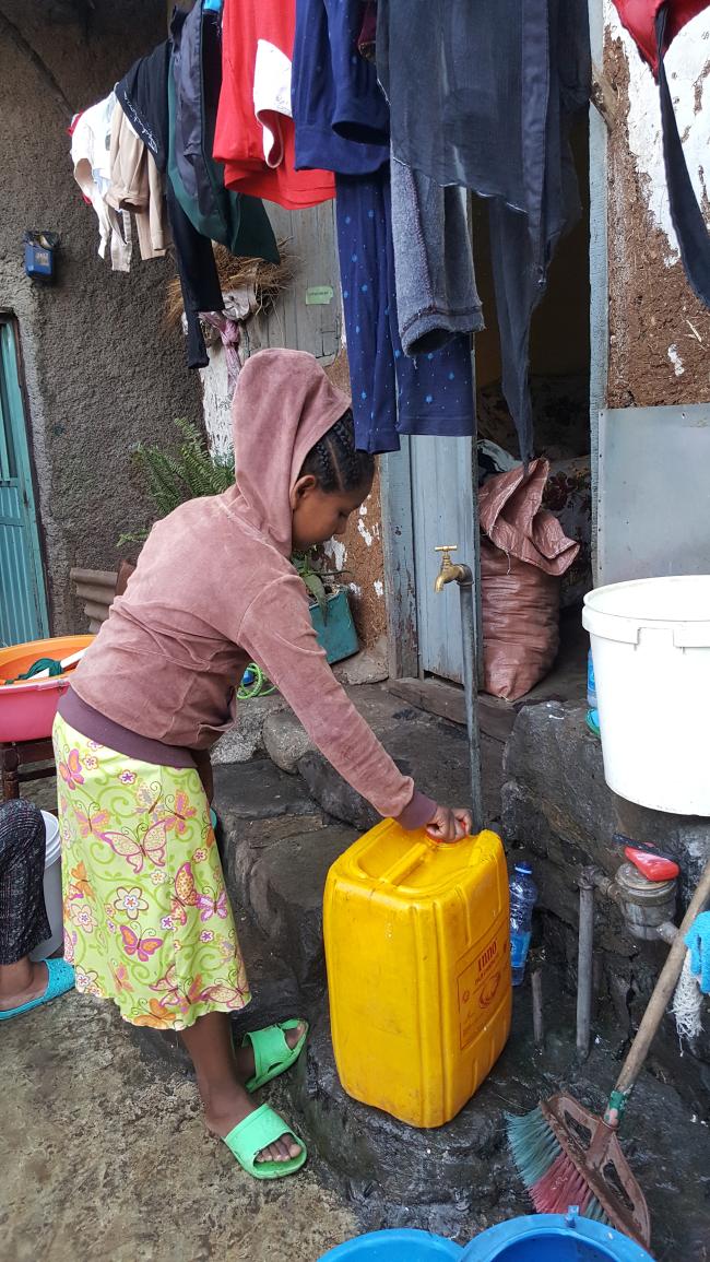 에티오피아의 한국전쟁 참전용사촌 굴렐레 마을에 사는 베쟈가 빨래가 너저분하게 널려 있는 집 앞 공동수도에서 물을 긷고 있다.  월드비전 제공