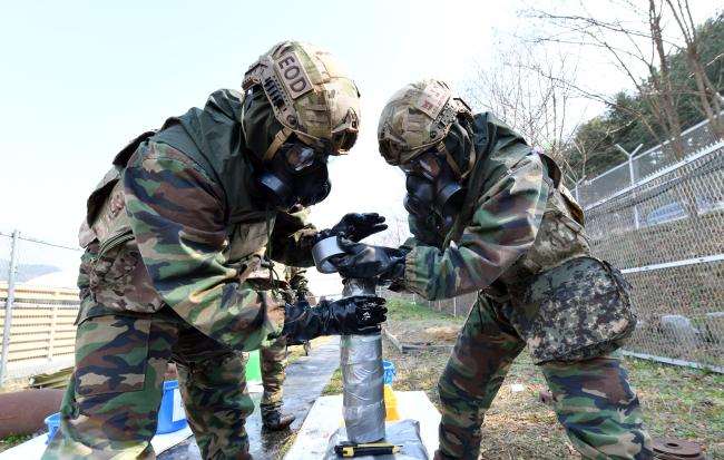 공군8전투비행단 폭발물처리반 요원들이 3일 부대 내 폭발물처리훈련장에서 화학불발탄의 화학작용제 누출 방지를 위한 밀봉 훈련을 하고 있다.
  사진 제공=전미화 중사
