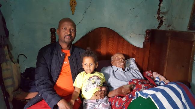 한국전쟁 참전 영웅 씨아므렌(오른쪽) 옹이 5년 전 다리를 크게 다쳐 침대에서 꼼짝하지 못하고 누워 있다. 먹지 못해 깡마른 그는 혼자서 대소변을 가리지도 못한다. 사진은 씨아므렌 옹과 아들 미케엘(왼쪽), 손녀 나후민 미케엘.  월드비전 제공