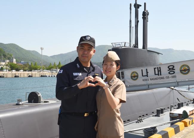 해군 부부 군인 김범준(왼쪽)·윤다정 대위가 21일 부부의 날을 맞아 기념사진을 찍고 있다.  부대 제공