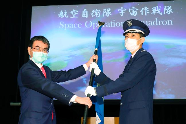 고노 다로(왼쪽) 일본 방위상이 지난 19일 도쿄의 방위성 본부에서 열린 우주작전대 창설 기념식에서 지휘관에게 부대기를 수여하고 있다.  연합뉴스