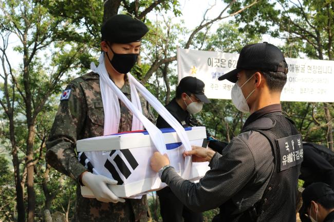 지난 21일 육군30사단 비호부대 장병들이 경기도 고양시 철마산 일대에서 발굴된 6·25 전사자의 유해를 부대 임시 봉안소에 안치하기 위해 운구하고 있다.  부대 제공