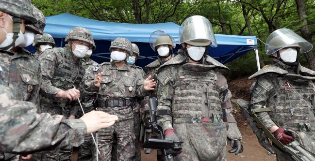 박한기(가운데) 합참의장이 25일 후방지역 방공진지 주변 지뢰제거작전 현장을 방문, 장병들을 격려하고 있다.  이경원 기자