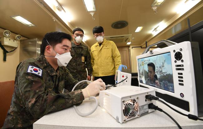 국방부가 ‘적극 행정’ 실천을 통해 코로나19 극복에 앞장서 ‘국민을 위한 군대’를 구현하고 있다. 사진은 지난 2월 중국 우한에서 귀국한 교민들이 머무르는 시설에 파견된 국군의무사령부 장병들이 이동전개형 의무시설 진료실에서 LTE 이동원격진료체계를 점검하는 모습.      조용학 기자