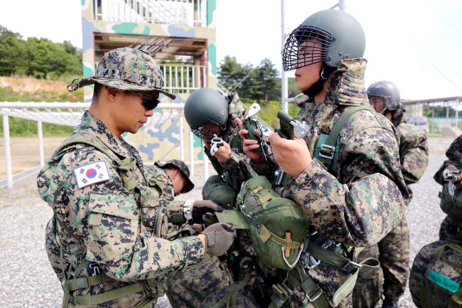 황준홍(왼쪽) 소령이 공수지상훈련을 앞둔 부대원의 복장과 장비를 점검하고 있다.