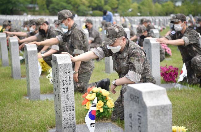  3일 국립대전현충원을 방문한 해군본부 장교, 부사관, 군무원들이 묘비마다 태극기를 꽂고 묘역 정화활동을 하고 있다.  해군 제공