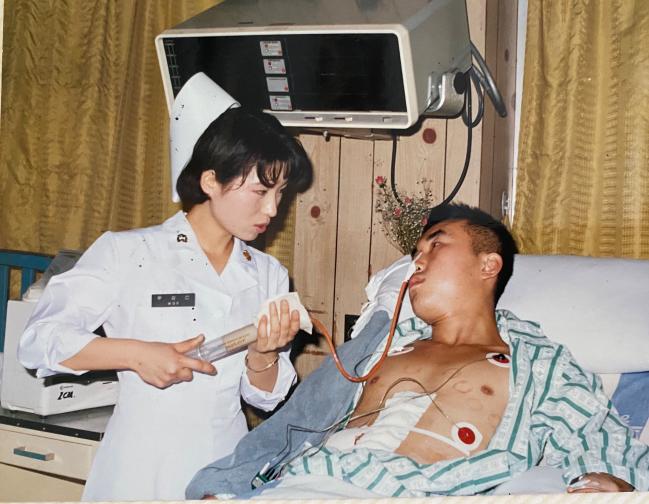 1990년 부산병원 간호장교가 환자에게 비위관 영양을 하는 모습. 