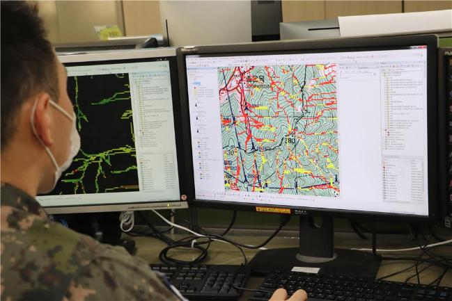 육군지상작전사령부 지형분석과 소속 간부가 ‘과학적 지형분석기법’ 프로그램인 ‘SINMAP’(왼쪽 화면)과 ‘TAUDEM’을 활용해 지뢰가 유실된 지역을 분석·예측하고 있다.  부대 제공 