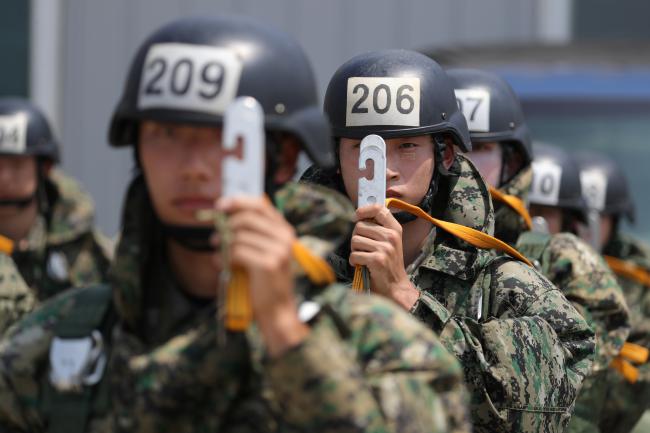 공중생환훈련이 열린 9일 공군17전투비행단에서 공군사관학교 3,4학년 생도들이 공중강하훈련을 위해 C-130 수송기 탑승에 앞서 강하장비와 낙하산 등을 착용완료 한 후 스태틱 라인(자동 열림줄 - 낙하산을 싼 주머니와 비행기를 연결하는 줄로 자동적으로 낙하산이 열리게 함)을 든채 대기하고 있다. 사진=조종원 기자 