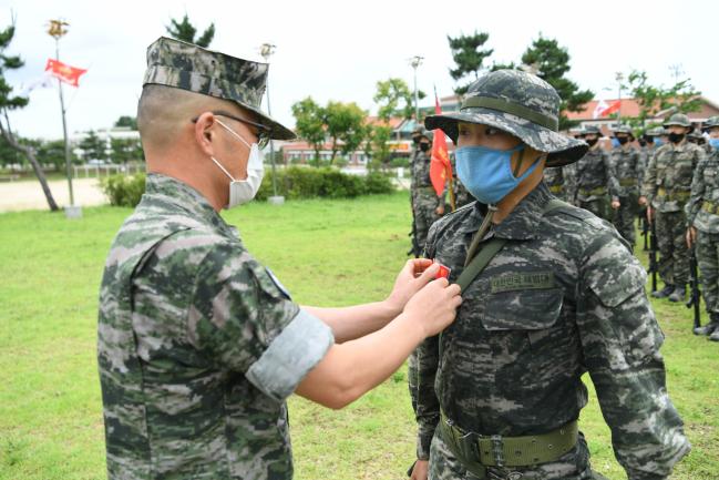 15일 경북 포항 해병대교육훈련단에서 박재필(대령(진)·왼쪽) 15해병교육연대장이 용석현 대대장생도에게 붉은명찰을 수여하고 있다.  부대 제공