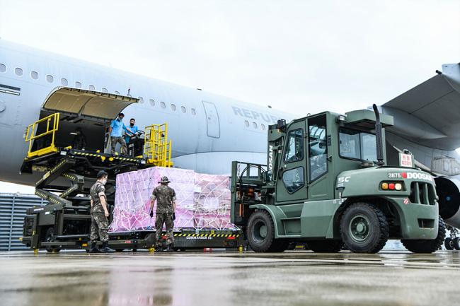 공군 장병들이 23일 공군 김해기지에서 이라크 교민을 귀국시키기 위한 공군공중급유기(KC-330)에 마스크 등 코로나19 방역물자를 적재하고 있다. 공군 제공