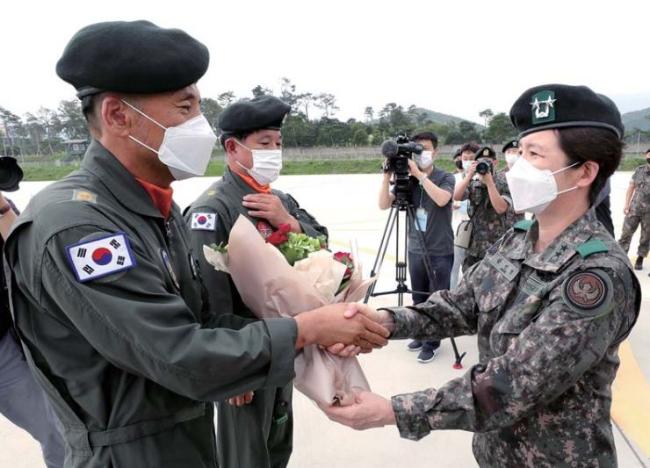 강선영(오른쪽) 육군항공작전사령관이 고별비행을 마친 조종사들에게 꽃다발을 증정하며 악수하고 있다. 조종원 기자