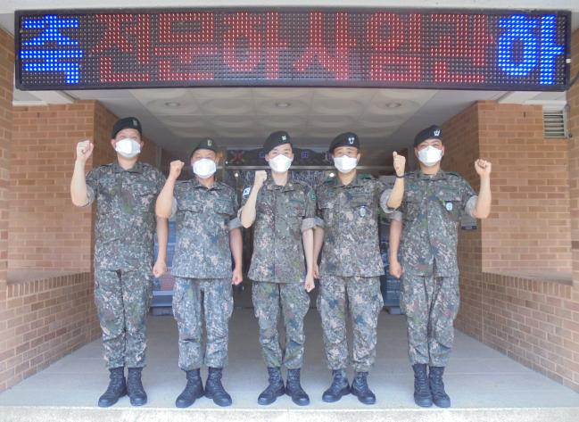 갑자기 찾아온 병마를 이겨내고 꿈에 그리던 전문하사로 임관한 김선민(가운데) 하사가 부대원들과 파이팅을 외치고 있다.  부대 제공 