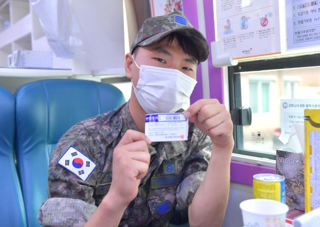 공군15특수임무비행단 ‘사랑의 헌혈운동’에 참여한 공병대대 송용진 병장이 헌혈증서를 들어보이며 포즈를 취하고 있다. 
 사진 제공=김샛별 중사 